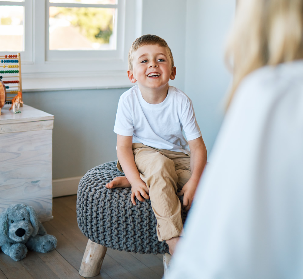 child sitting on a stool for Speech and Language therapy